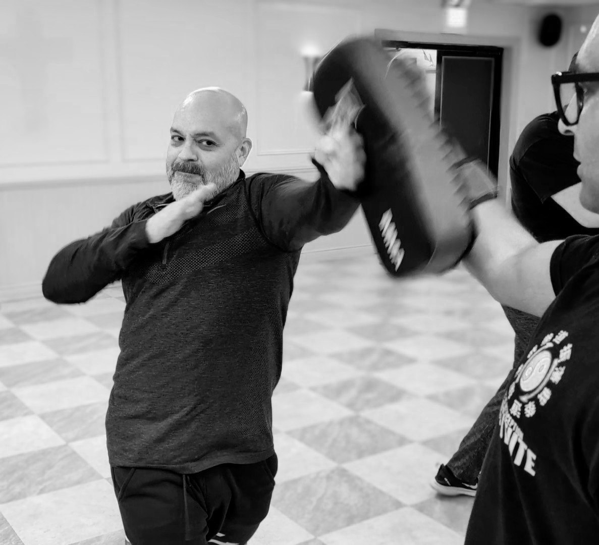 Student striking a kick shield