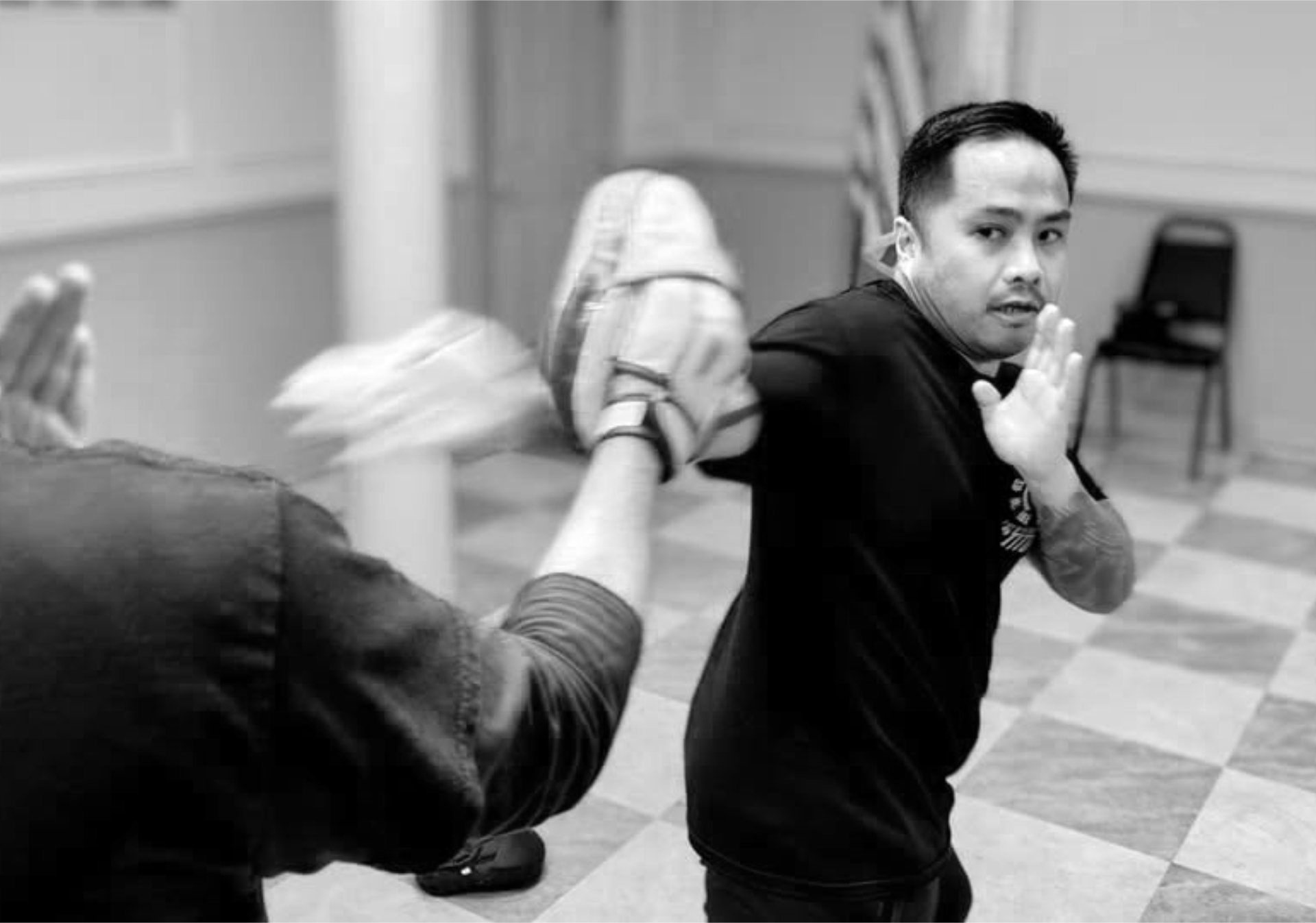 Student in fighting stance with a partner holding a focus mitt